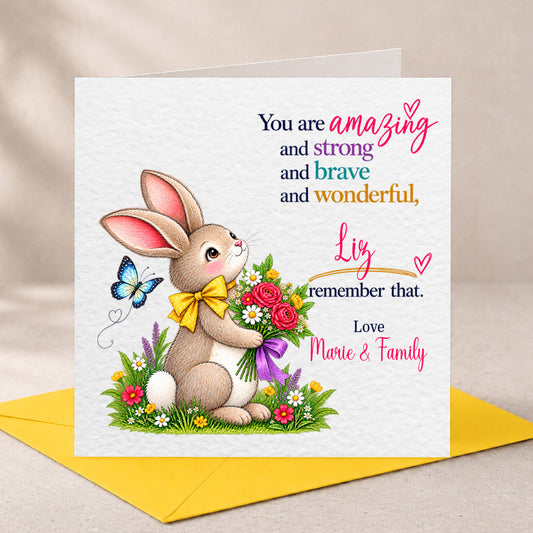 A square Easter greeting card with a white textured background, featuring an illustrated brown bunny holding a bouquet of red, pink, and white flowers with a yellow bow. The card has personalized text in black, pink, blue, and orange.