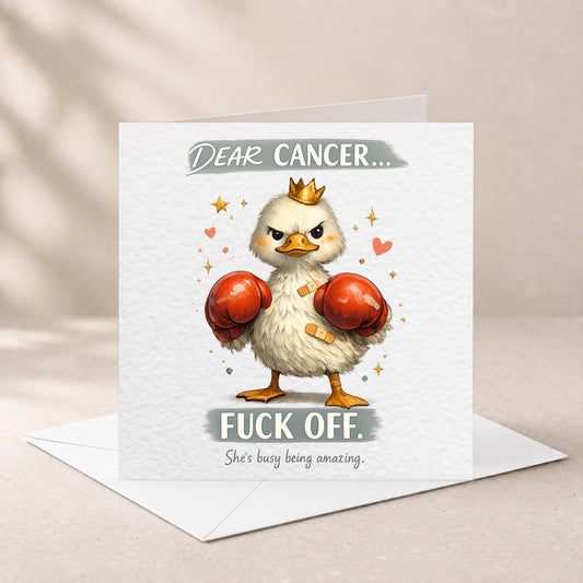 A square greeting card with a white envelope behind it, featuring an illustration of a white chick wearing a gold crown and red boxing gloves, with the text 'DEAR CANCER.