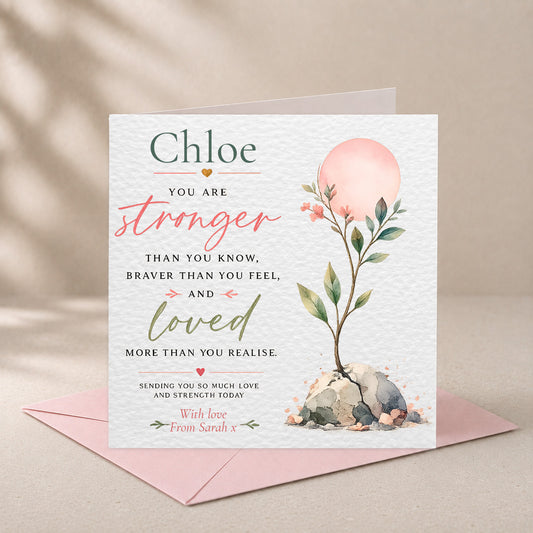 A personalized greeting card with a watercolor floral design and supportive message, displayed with a pink envelope on a neutral beige background.