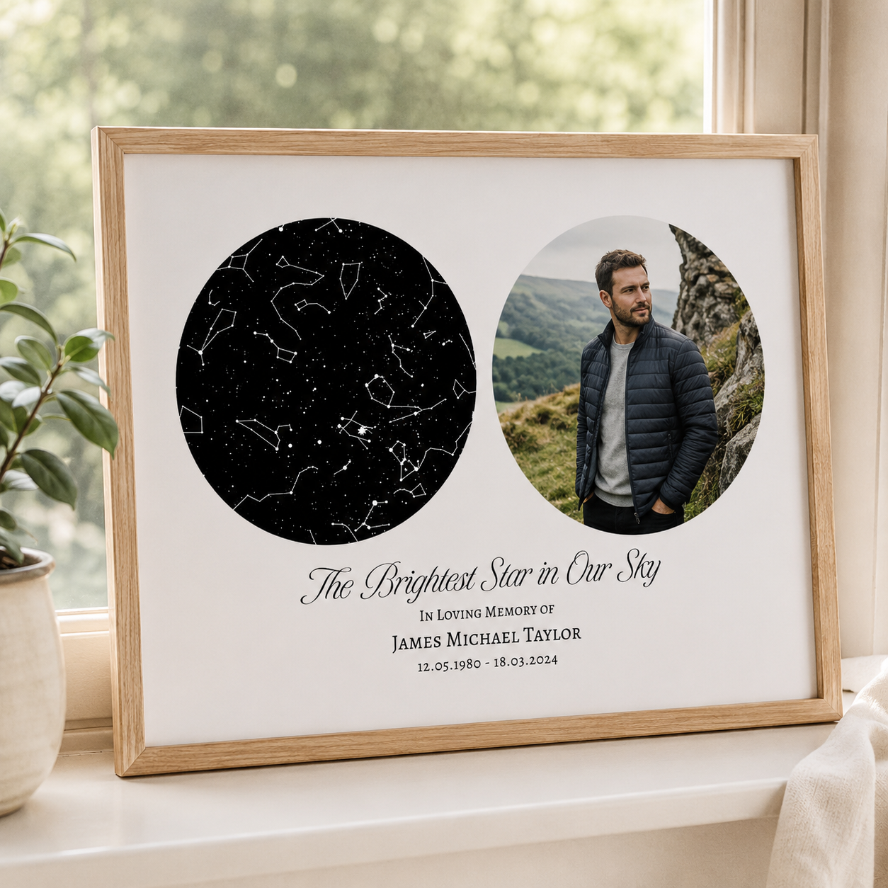 A framed memorial print leaning on a windowsill in a real indoor setting. The print has a light wood frame and a white background, with two circular custom images: a black star constellation design on the left and a circular photo of a man on the right.