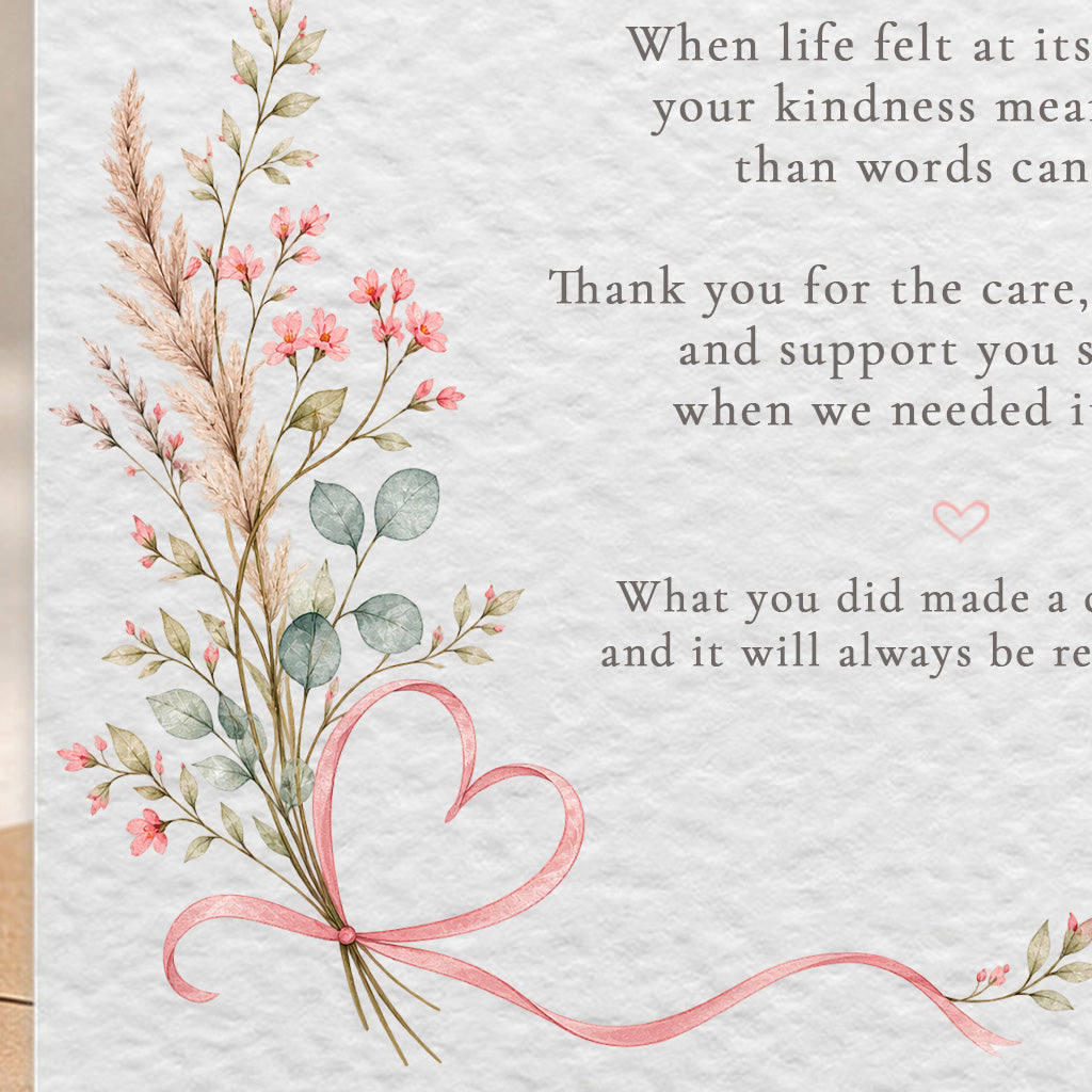 A close-up of a printed card or letter with a watercolor-style bouquet of pink flowers, green leaves, and a pink ribbon bow on the left, alongside partial black text on a textured off-white background.