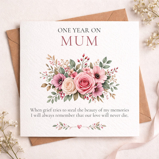 A square floral 'One Year On Mum' greeting card displayed on top of a brown envelope, surrounded by dried baby's breath flowers on a light beige surface.