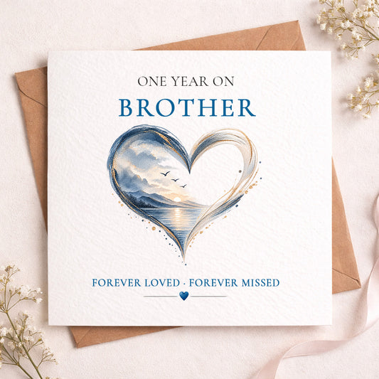 A square white memorial card for a brother, styled on top of a brown envelope with dried flowers. The card features a watercolor heart design with a landscape scene and the text 'ONE YEAR ON BROTHER' and 'FOREVER LOVED - FOREVER MISSED'.