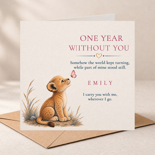 A square sympathy or remembrance card with a kraft envelope, featuring an illustration of a cub sitting beside a butterfly and printed text that reads 'ONE YEAR WITHOUT YOU' and 'EMILY'.