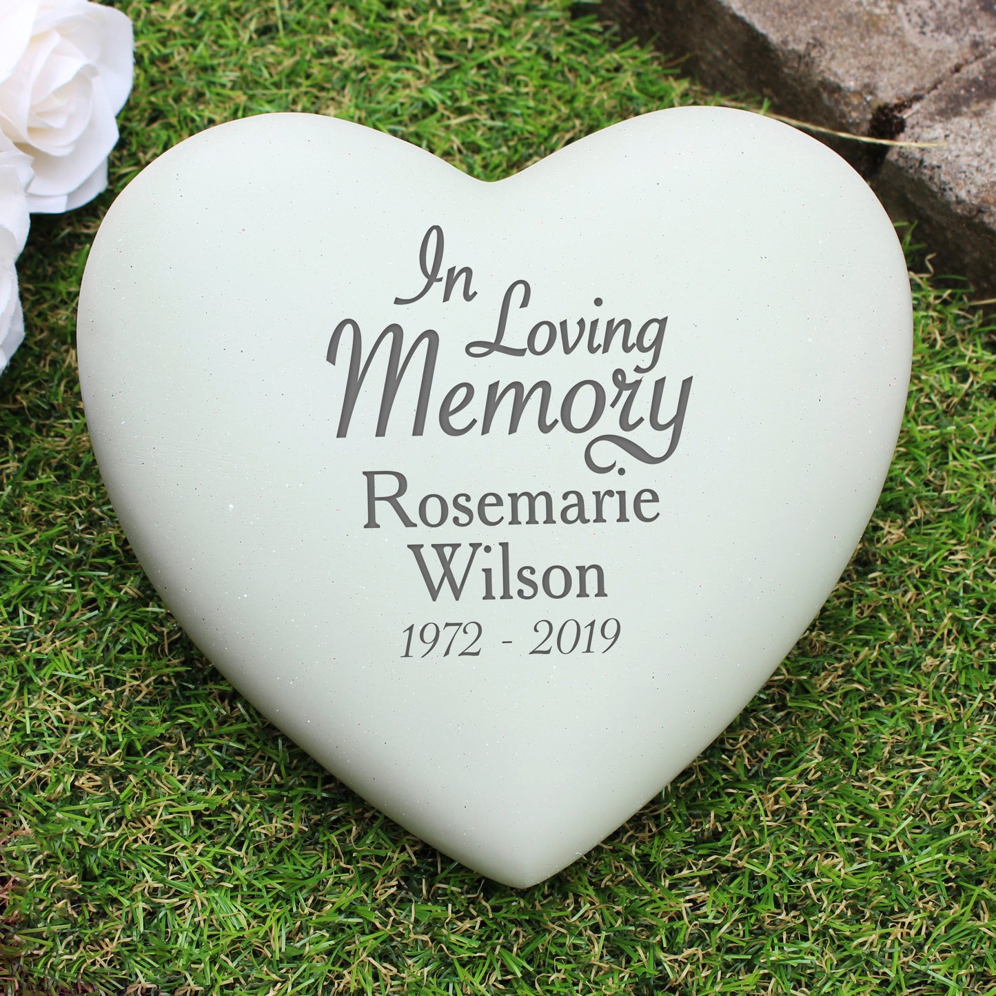 Heart-shaped memorial stone with engraved text on grass