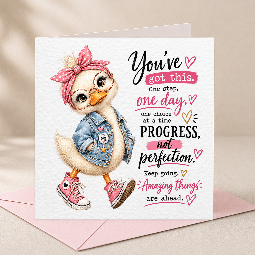 A square greeting card with a white textured background, featuring a cute cartoon duck wearing a pink polka-dot bow headband, denim jacket, and pink sneakers, alongside motivational text. The card is displayed on a light pink envelope against a soft beige fabric backdrop.