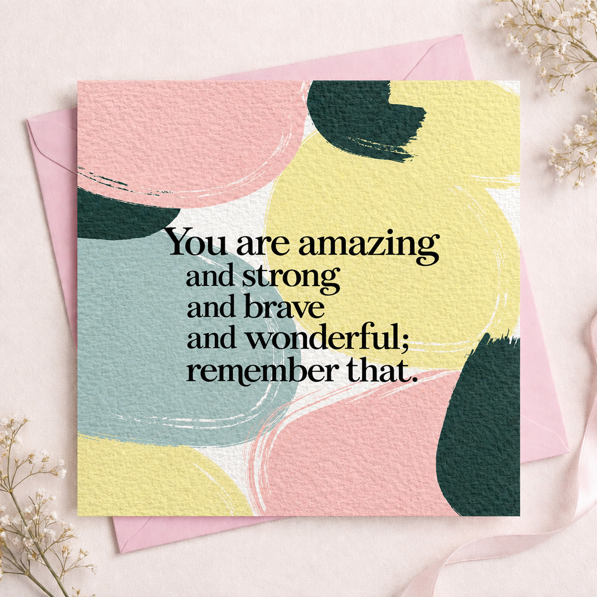 A square greeting card with abstract pastel brushstrokes in pink, yellow, teal, and dark green, printed with the supportive message, 'You are amazing and strong and brave and wonderful; remember that.' in black serif text.
