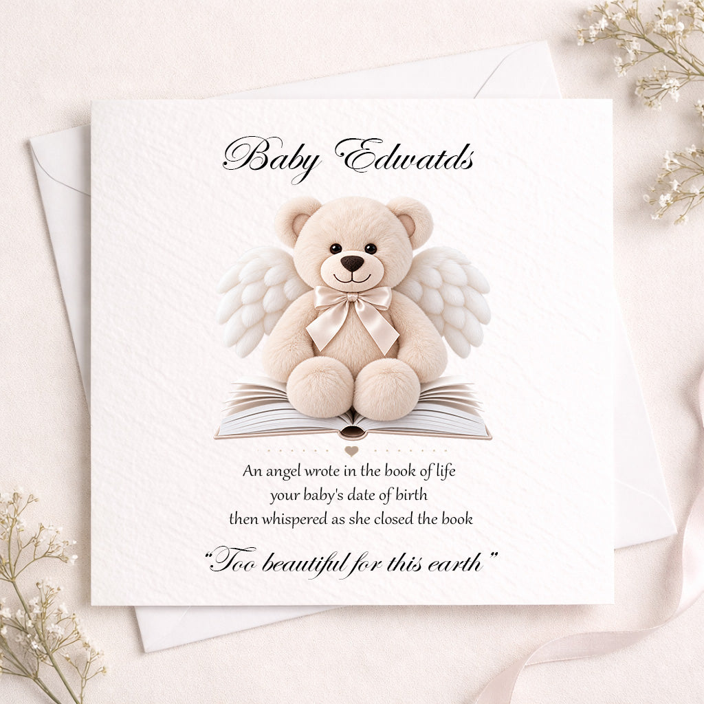 A square white baby memorial card featuring a teddy bear with angel wings and a bow, sitting on an open book. The card reads 'Baby Edwards' at the top and includes a memorial quote below.